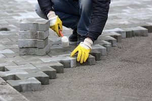 Worker installing a Concrete Paver Driveway.