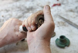 Man Tightens Part Of Lawn Sprinkler