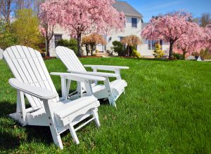 Adirondack chairs in front yard of house with brilliant spring lawn care and landscaping