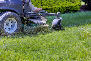 Riding lawn mower cutting grass .