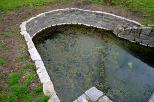 A small residential rentention pond with stone and mortar lining to prevent erosion.