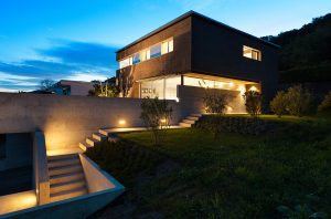 Modern home illuminated with exterior lighting at dusk.