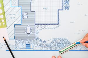 A blueprint sketch of a backyard with hand tools.